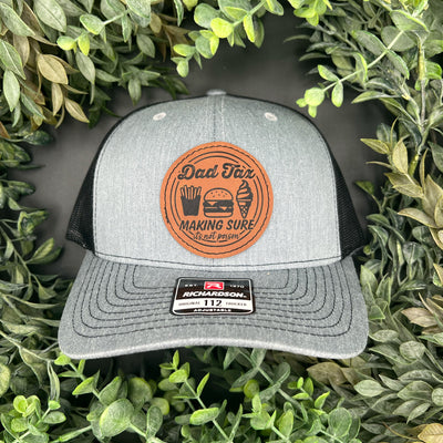 Hat with an engraved leatherette patch that says, Dad Tax: Making sure it's not poison.