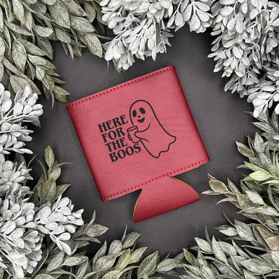Red can cooler with ghost and text design surrounded by greenery