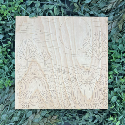 Wooden plaque with pumpkin design on a green leaf background